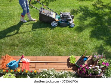 Woman Mowing With Lawn Mower In The Garden, Gardening Concept 