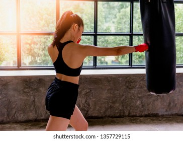 Woman muay thai boxer fighting. Fit young female boxer in sportswear.