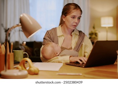 Woman multitasking by breastfeeding baby while working at laptop in cozy home office with warm lighting. Scene demonstrates tenderness and professional dedication - Powered by Shutterstock