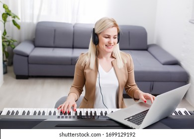 woman musician playing classic digital piano at home during online class at home, social distance during quarantine, self-isolation, online education concept