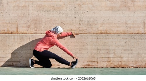 Woman with muslim sport wear stretching - Shutterstock ID 2062662065