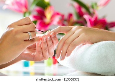 Woman In A Nail Salon Receiving A Manicure By A Beautician