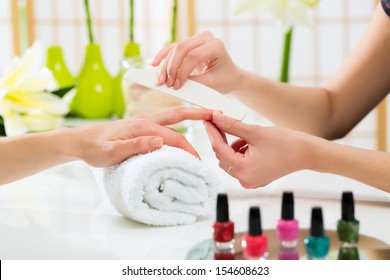 Woman In A Nail Salon Receiving A Manicure By A Beautician