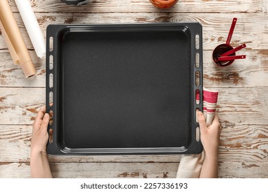 Woman with napkin and baking tray on wooden background