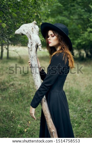 woman in nature with an attribute in her hands