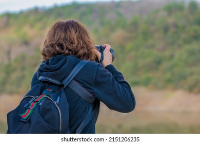 Woman nature photographer. A woman taking a photo with her back turned. Landscape shooting.
 - Shutterstock ID 2151206235