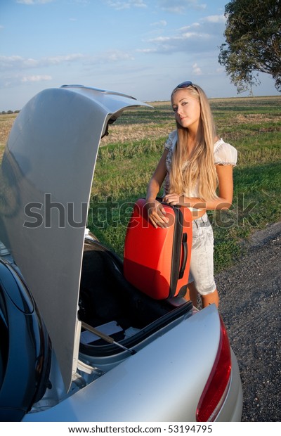 Woman near the car, with\
her baggage