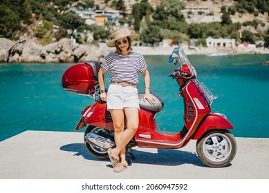 Woman Near Scooter Motor Bike In Candy Apple Red Color, Pier In Luxury Resort. Amazing Turquoise Sea Water Background. Moped, Mode Of Transport Concept. High Quality Photo