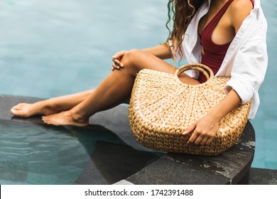 Woman near swimming pool holding in hands handmade straw wicker beach bag. Eco-friendly and zero waste tropical lifestyle. Organic and natural, plastic free. - Powered by Shutterstock
