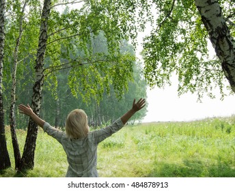 Woman near trees raised their hands. The concept of ecology and nature protection.