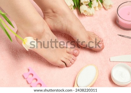 Woman with neat toenails after pedicure procedure on pink terry towel, closeup