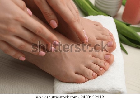 Woman with neat toenails after pedicure procedure on white wooden floor, closeup