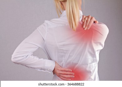 Woman With Neck / Back Pain. Business Woman Rubbing Her Painful Back Close Up. Pain Relief Concept