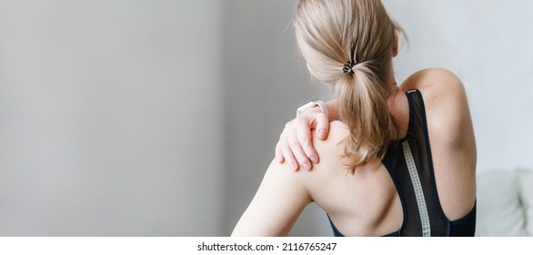 Woman with neck and back pain. Woman rubbing his painful back close up. Pain relief concept. - Shutterstock ID 2116765247