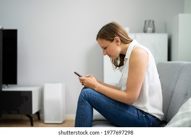 Woman With Neck Pain Sitting Using Mobile Phone