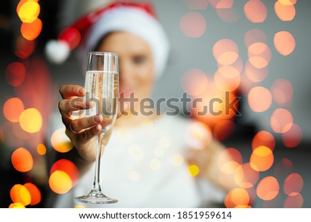Woman in New Year's cap with a glass of champagne, Christmas holiday and fun