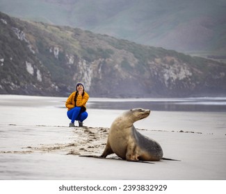 woman and new zealand sea lion posing for a picture together; cute new zealand wildlife spotted in otago peninsula, south island