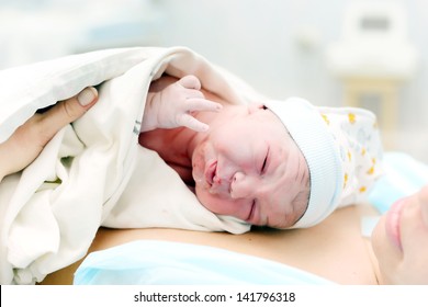 woman with a newborn baby. birth in hospital. baby after birth. child one day.
