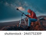 woman next to a telescope observing the night sky in the desert	