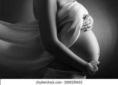 woman in the ninth month of pregnancy, Pregnant Woman Belly. Pregnancy Concept. Isolated on Black Background. Black and white pregnant tummy close up