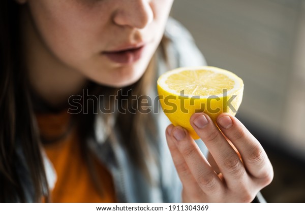 Woman Nose\
Sniffing Lemon Smell. Coronavirus\
Symptom