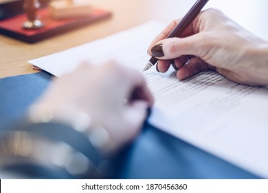 Woman notary public signing last will testament document - Powered by Shutterstock