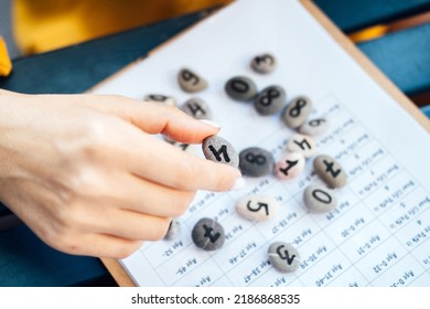 Woman Numerologist Hand With Pebble Stone With Number Four 4. Selective Focus