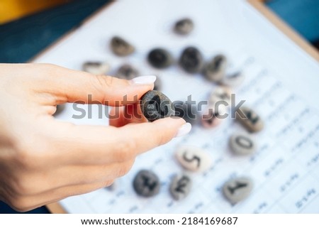 Woman numerologist hand with pebble stone with number two 2. Numerology Numbers Concept. Selective focus Stock photo © 