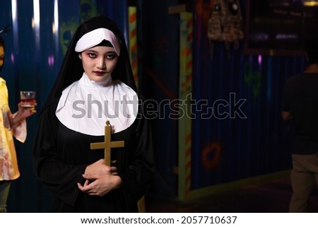 Woman in the nun at Halloween party at night. Young evil asian woman nun scare.