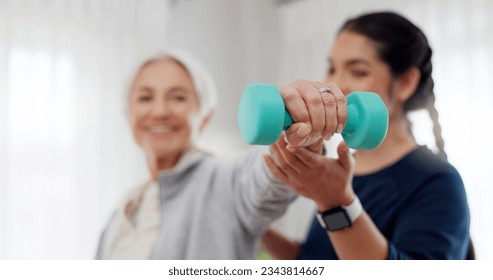 Woman, nurse and dumbbell in elderly care for physiotherapy, exercise or workout at old age home. Female doctor, caregiver or personal trainer helping senior patient in weightlifting for healthy body
