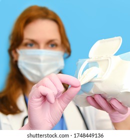 Woman Nurse In Medical Mask With Cleaning Wipes On A Blue Background, Close-up Face.