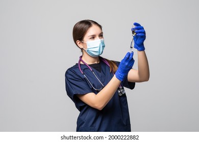 Woman Nurse with protective workwear holding Vaccine and syringe on white background. Female doctor with face mask gloves in Hospital, preparing vaccine. - Powered by Shutterstock