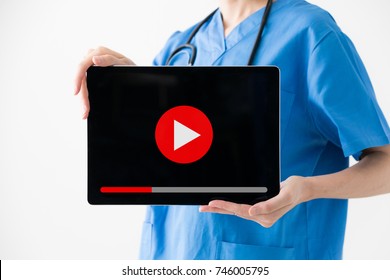 Woman Nurse Showing Movie Play Button.