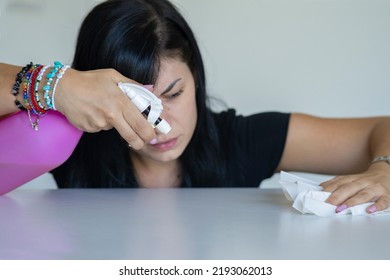 Woman With Obsessive Compulsive Disorder Cleaning Table With Detergents. OCD Concept.