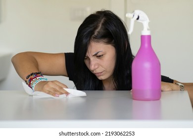 Woman With Obsessive Compulsive Disorder Cleaning Table With Detergents. OCD Concept