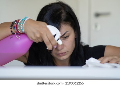 Woman With Obsessive Compulsive Disorder Cleaning Table With Detergents. OCD Concept.