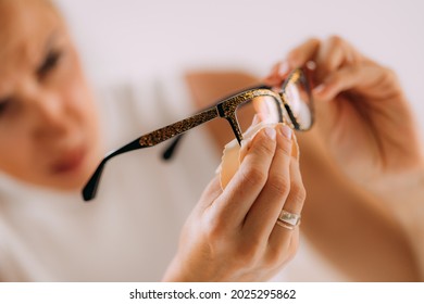 Woman With OCD Or Obsessive Compulsive Disorder. Cleaning Her Eyeglasses.