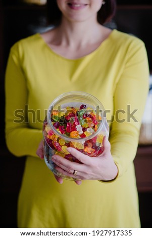 Woman offers gummy bears from glass jar