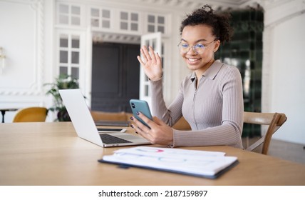 A woman in the office video communication chat online communication uses a laptop, answers the client's mail and phone - Shutterstock ID 2187159897