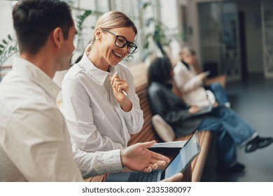 Woman office worker discussing new project with colleague during working day in coworking - Powered by Shutterstock
