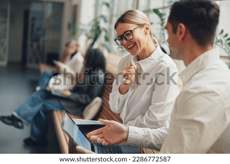 Woman office worker discussing new project with colleague during working day in coworking