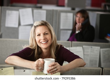 Woman Office Worker Enjoys A Cup Of Coffee At Her Cubicle