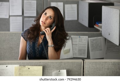 Woman office worker rolls eyes while on telephone
