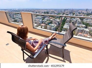 Woman On A Balcony In Downtown Of Modern City