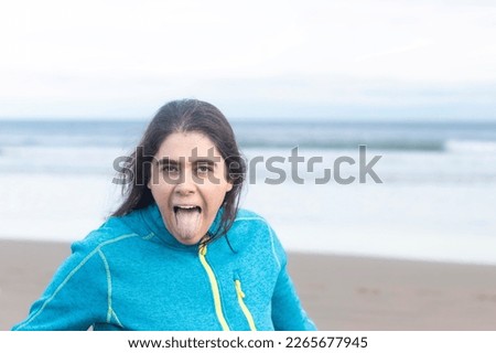 woman on the beach making fun sticking her tongue out at the camera