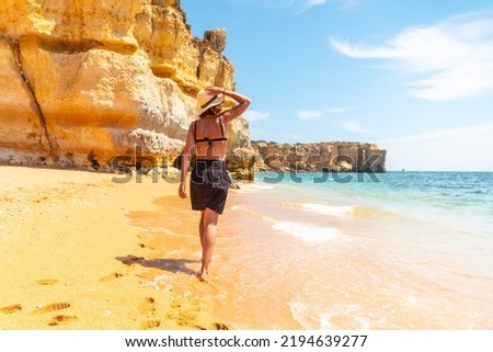 A woman on beach vacation at Praia da Coelha, Algarve, Albufeira. Portugal