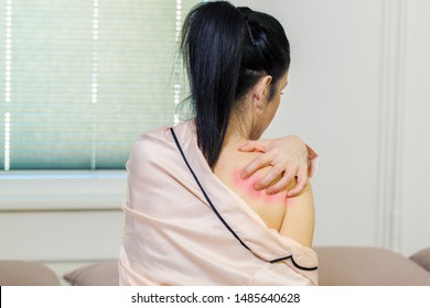 Woman On Bed In Pajama Scratching Her Itchy Shoulder.Healthcare And Medical Concept. Cause Of Itching From Skin Diseases