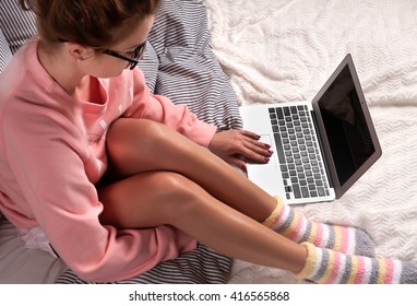 Woman On A Bed In Pink Pajama Using Laptop