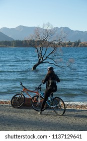 Woman On Bike By Lake Wanaka In New Zealand