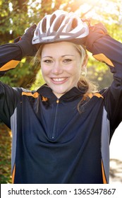 Woman On Bike Ride Puts On Cycling Helmet As Protection In Case Of Fall Or Accident